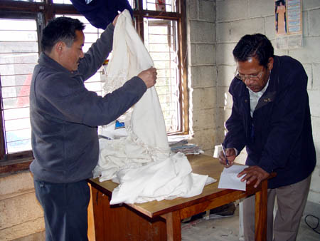Tsering at the dying shop, handing over the shawls produced that morning.